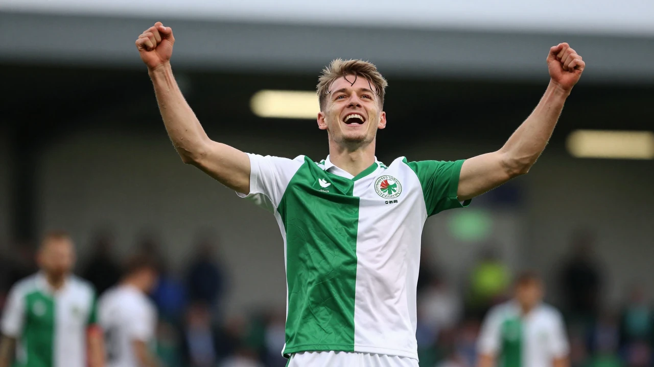 Waist-up shot of a young Shamrock Rovers player in a green and white jersey, arms raised in jubilation, eyes shining with...
