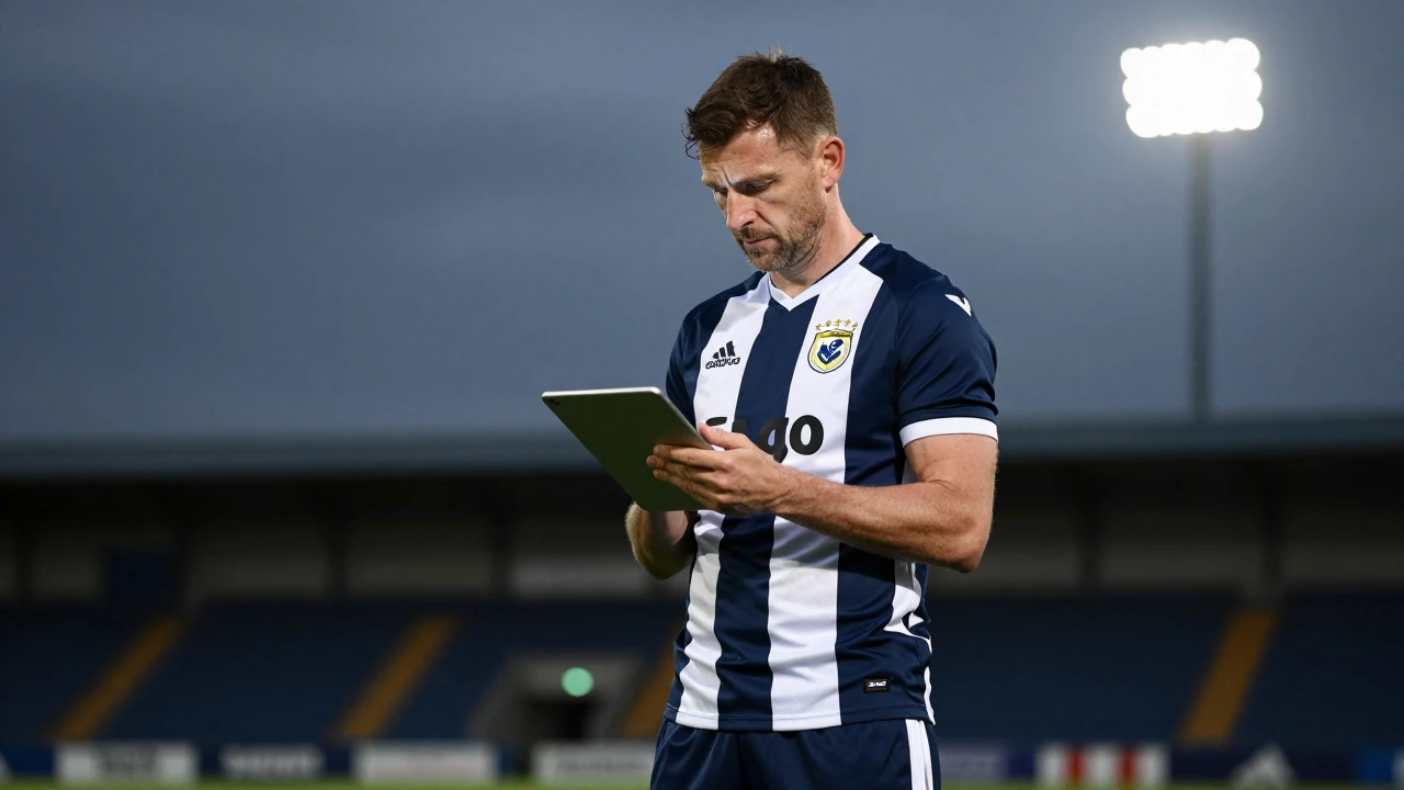 Ruaidhri Higgins, mid-40s, stands confidently on the sidelines in a dark blue and white striped jersey, eyes focused...