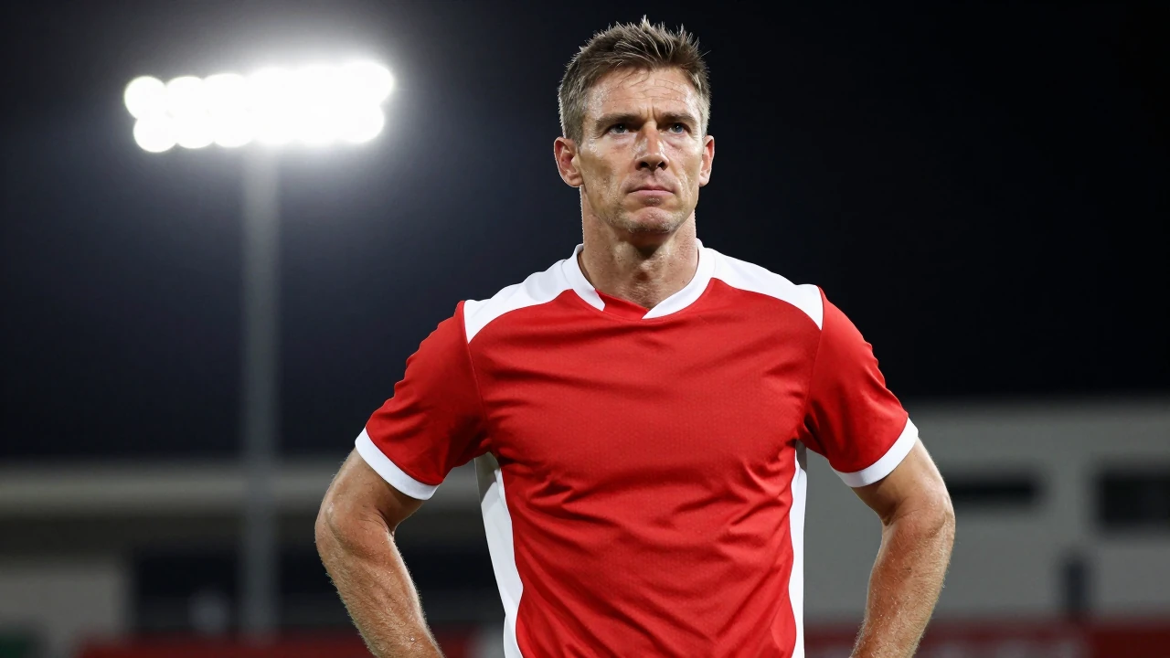 Waist-up shot of a young, muscular Le Mans FC coach in a clean red and white jersey, 30s, eyes focused determinedly into...