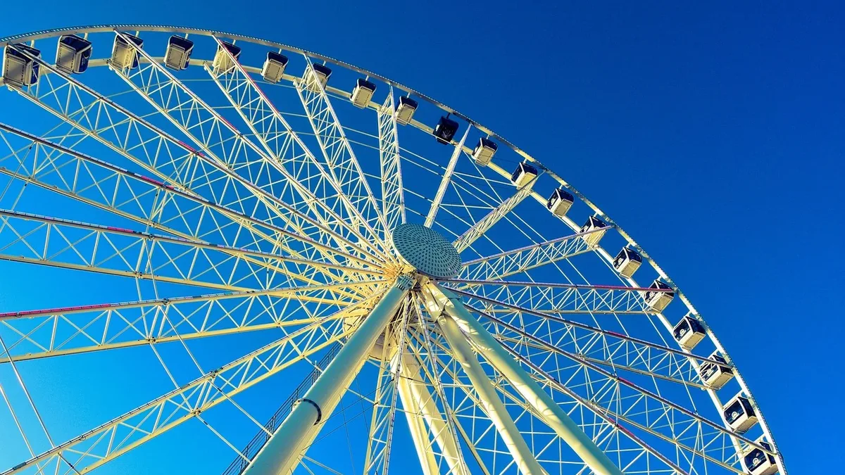 Film: The lower half of a large Ferris wheel, with a clear blue sky in the background.