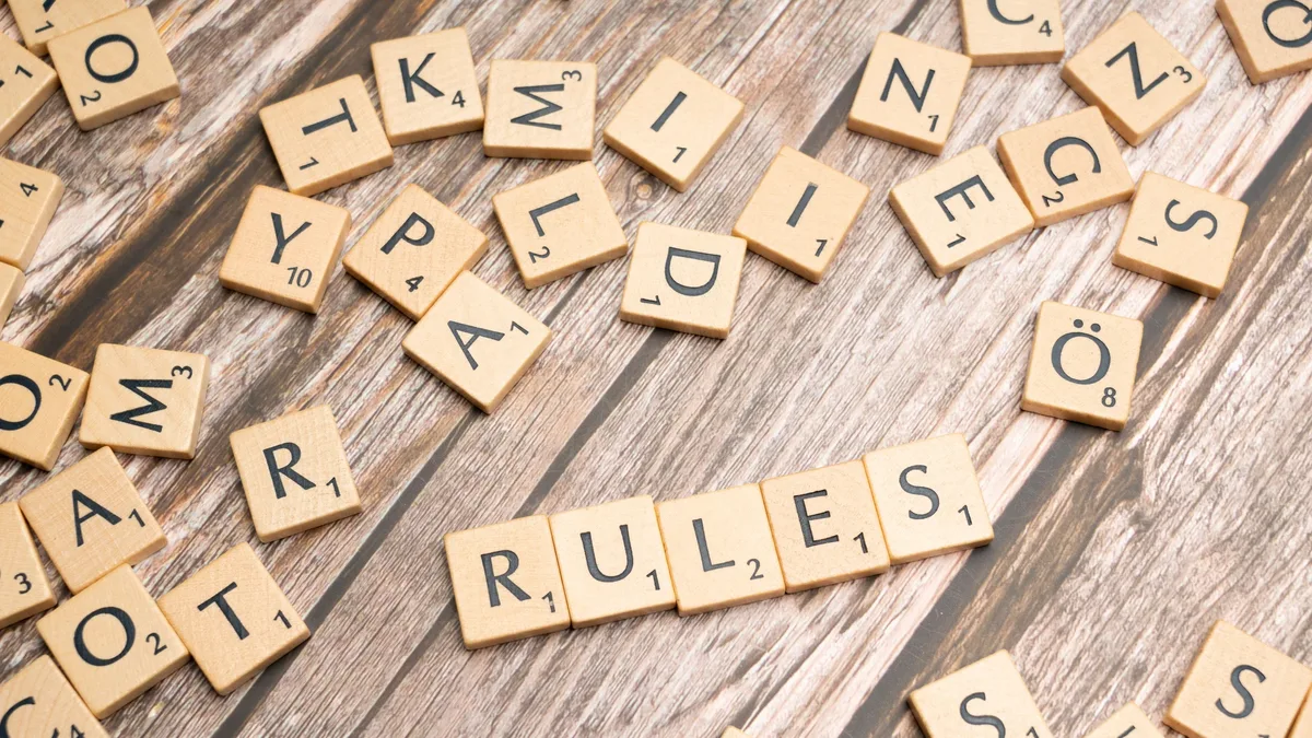Elections: Wooden letter tiles arranged to spell 'Rules' on a textured wooden background.