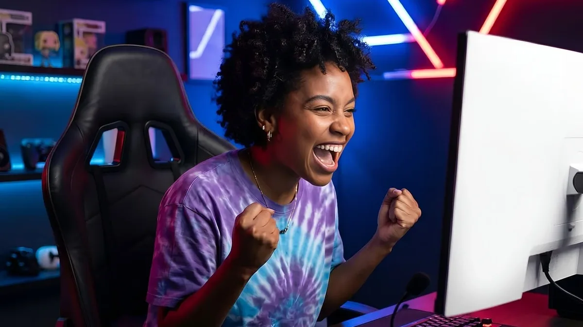 Teams: A woman sitting at a desk in a room with a computer, keyboard, mouse, headphones, and a chair.