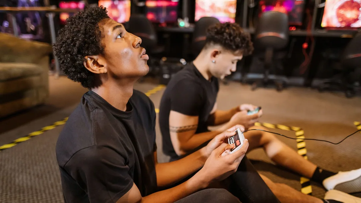 Teams: Two teenagers deeply engaged in a video gaming session at an indoor arcade. Esports close up
