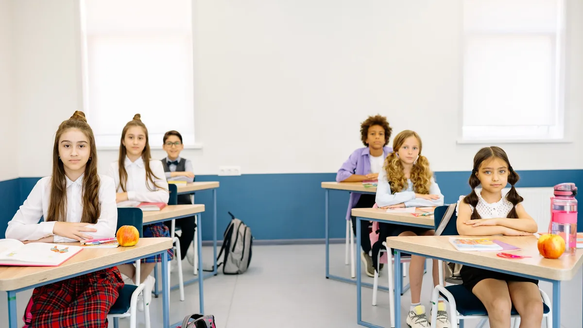 Policy: Children attentively studying in a bright classroom, promoting diverse learning environments.