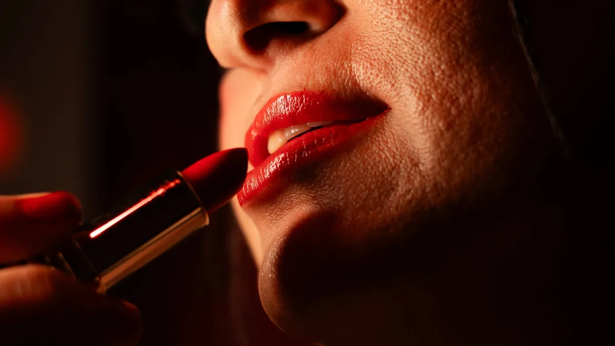 Lauren and Alex from Defector attempt a red lip look as part of Reds Week, sharing their personal histories with lip...