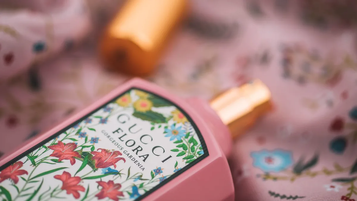 Houses: Elegant close-up of Gucci Flora perfume with floral design, highlighting luxury.