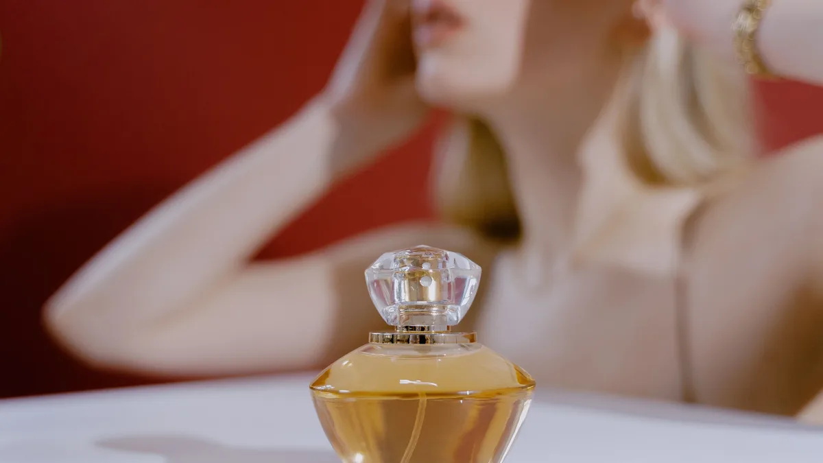 Perfumers: Stylish perfume bottle with a blurred woman in the background, capturing elegance and aroma. Fragrance