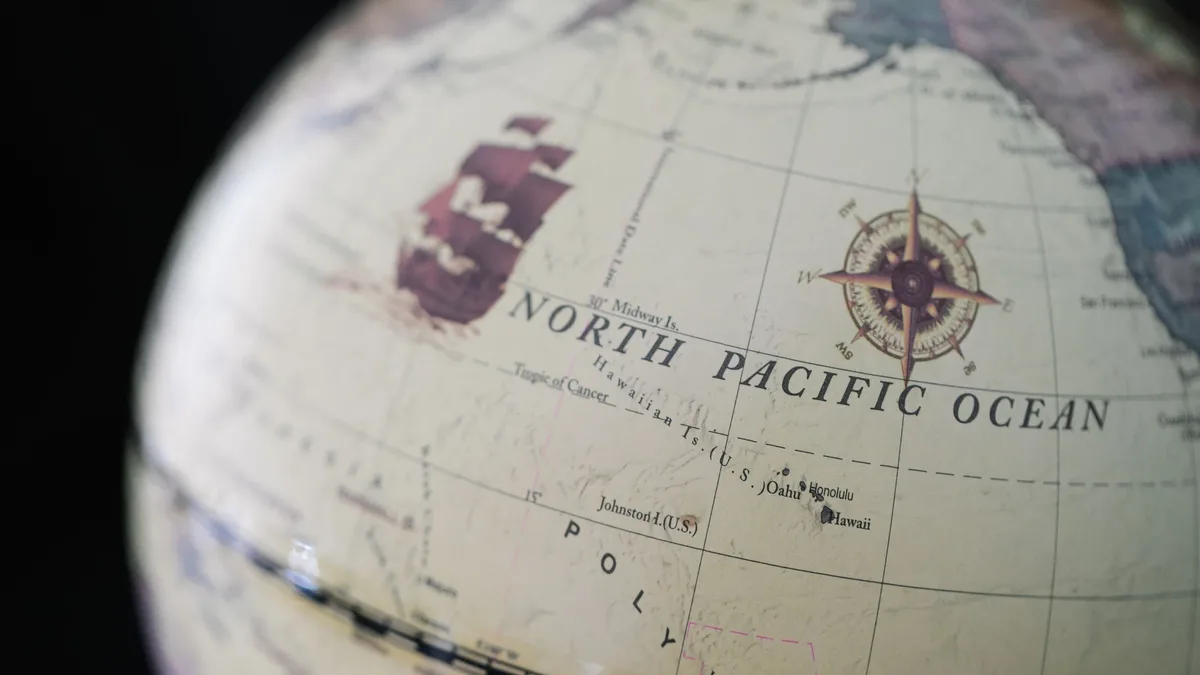Trails Routes: Close-up of a vintage globe displaying the North Pacific Ocean and surrounding areas.