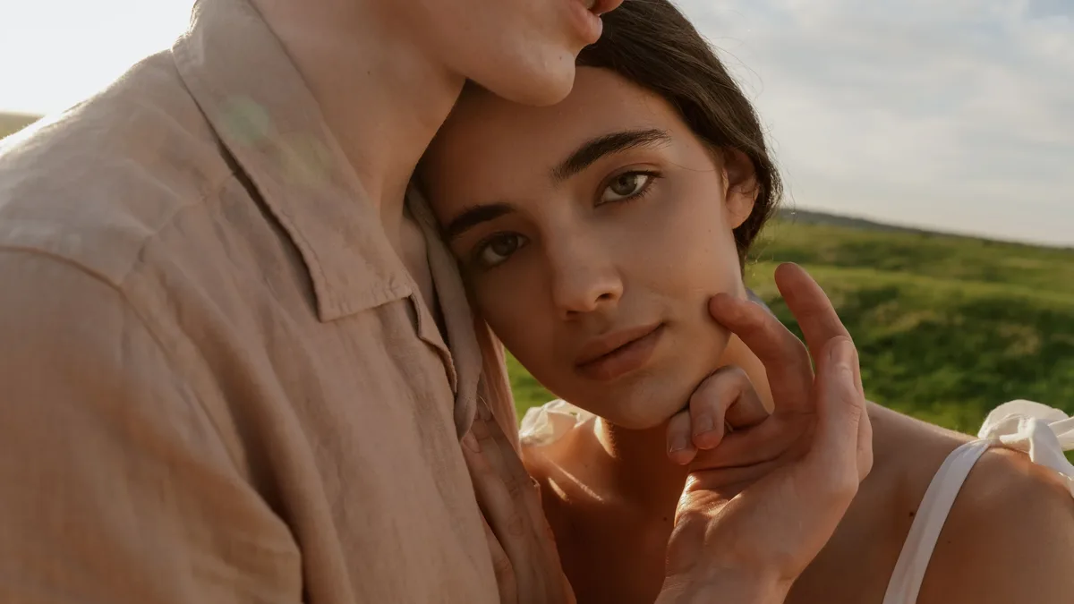 Difficulties: A warm intimate moment captured between a couple embracing in a natural setting.
