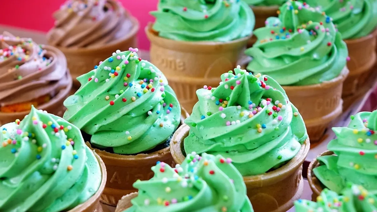 Culture: A tray of ice cream cones with green frosting and sprinkles.