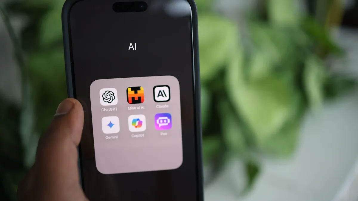 Regulation: Close-up of a hand holding a smartphone with AI applications on screen.