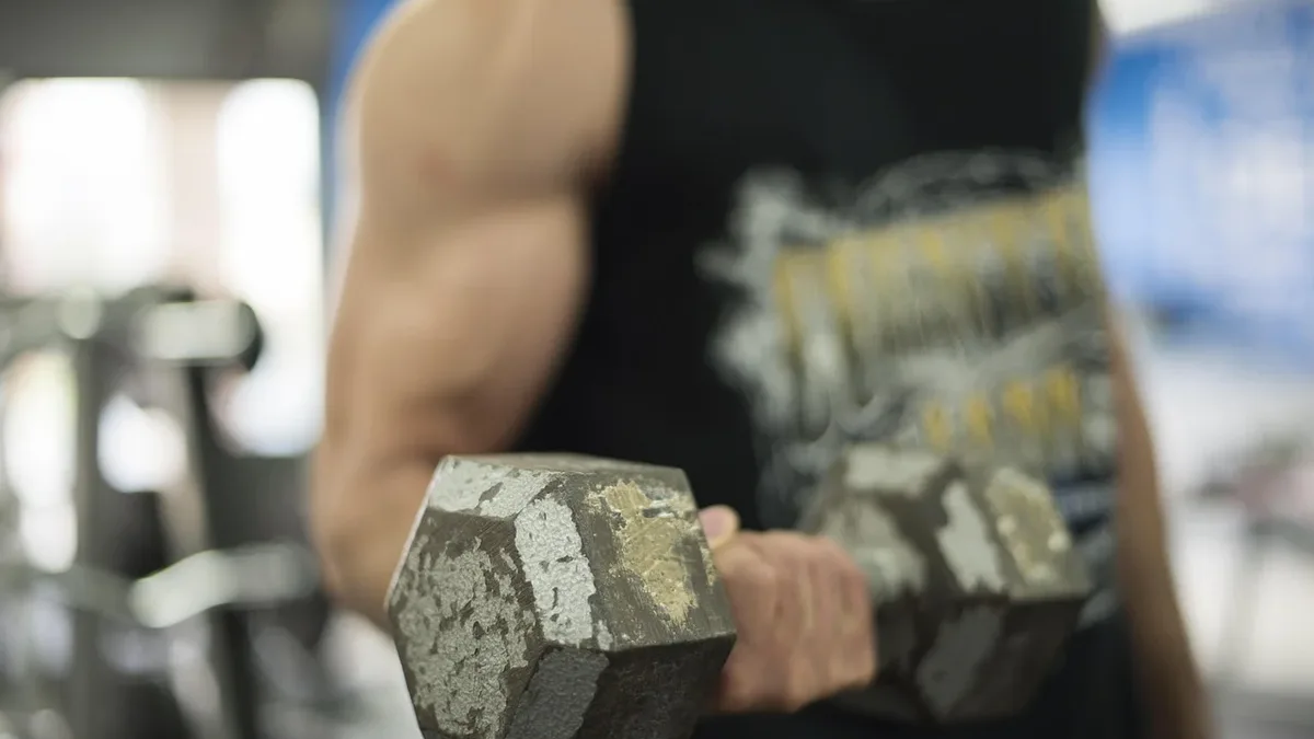 A fitness coach shares a dumbbell finisher that combines curls and isometric holds for a challenging arm pump, requiring...