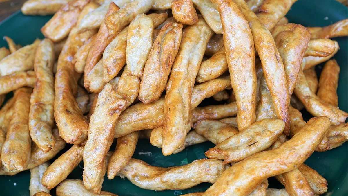 A recipe for crispy fried eggplant sticks seasoned with salt, white pepper, and five spice powder, using a double-fry...