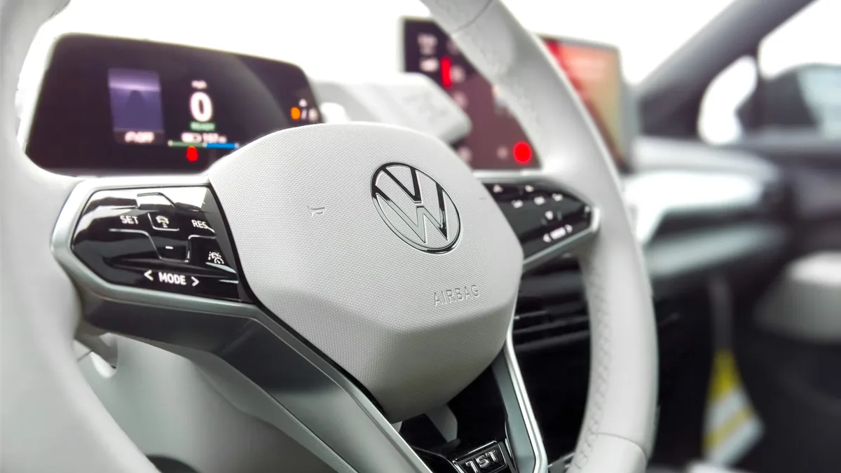 Compare: Detailed view of Volkswagen steering wheel in a modern car interior.