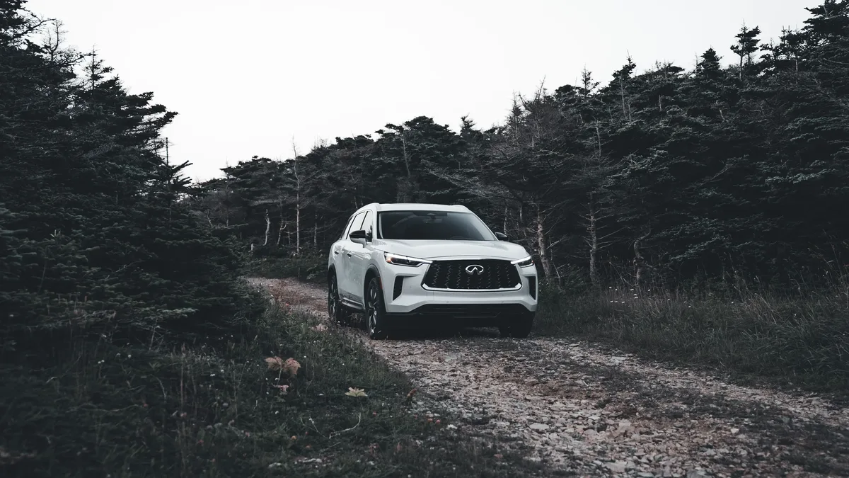 Compare: A white SUV navigates a rugged forest trail, showcasing its off-road capability in a winter landscape.