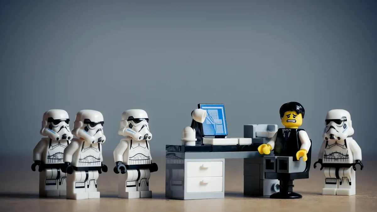 Seasons: A Lego scene featuring a Lego man standing at a desk, surrounded by five Lego stormtroopers.