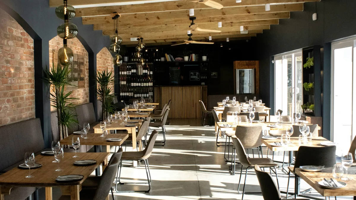The Business: A restaurant with tables and chairs and a brick wall.