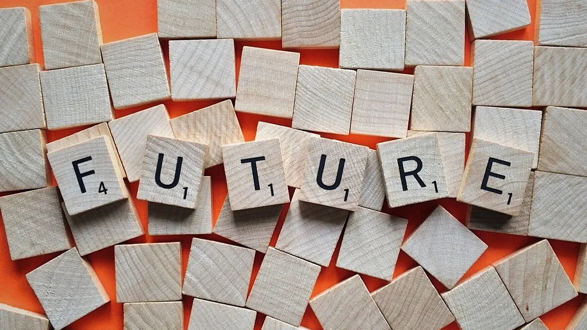 A collection of wooden Scrabble tiles arranged in a random pattern, with the word "FUTURE" prominently displayed in the