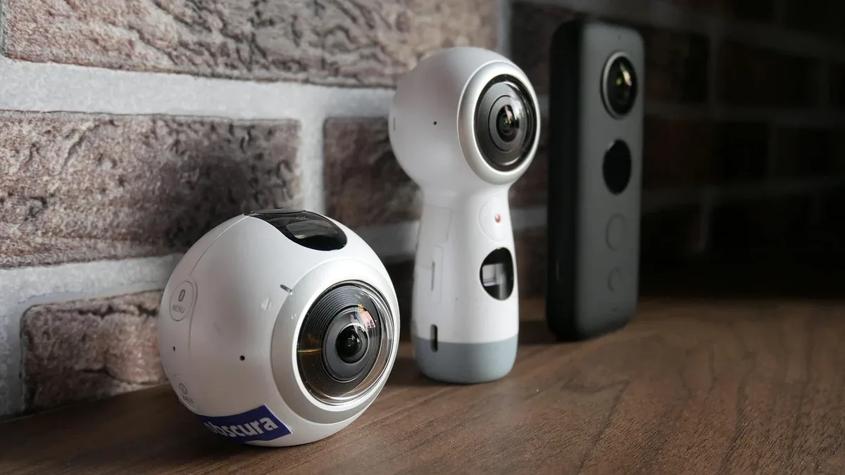 Gear: Three 360-degree cameras on a wooden surface in front of a brick wall.
