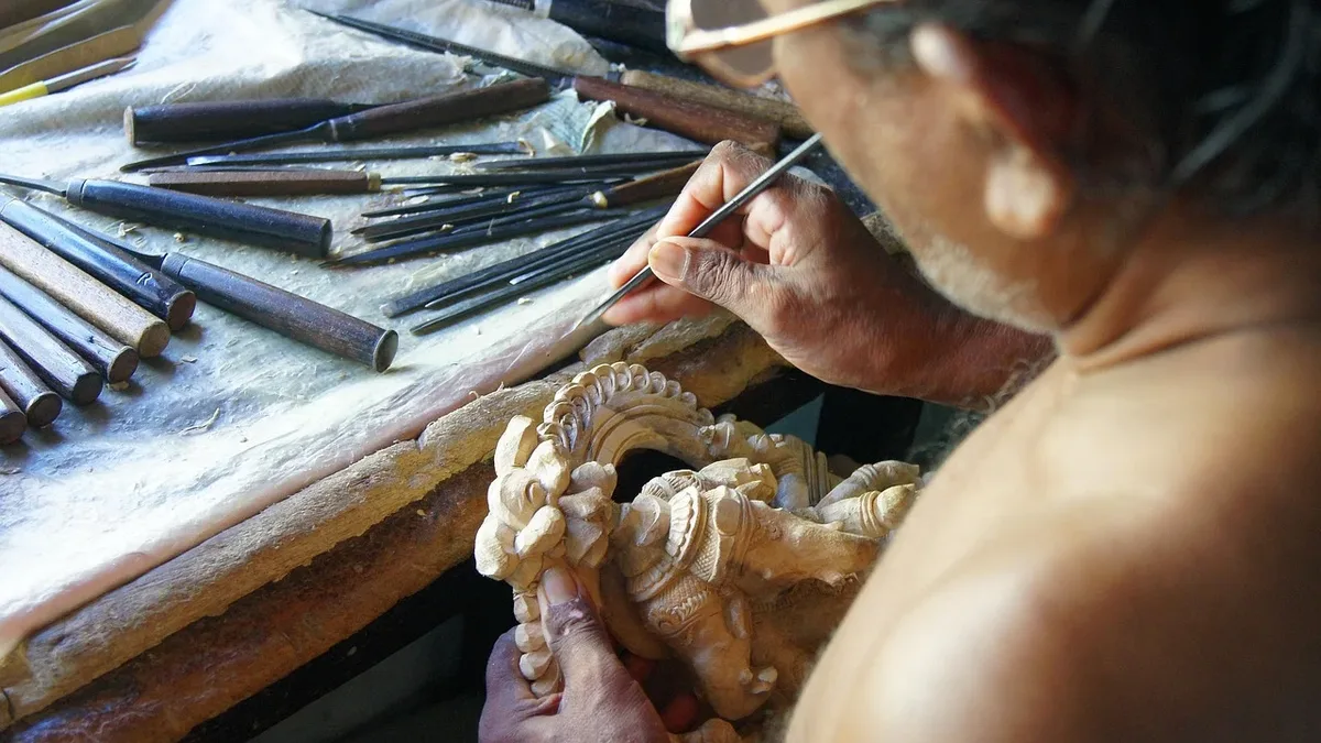 Drones: A man carving a piece of wood with a tool, surrounded by various tools and materials on a table.