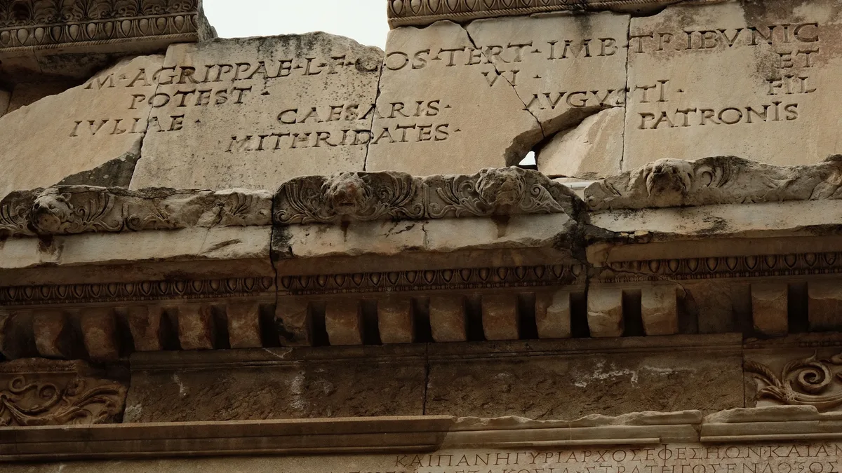 News: Close-up of ancient Roman architecture featuring Latin inscriptions carved into stone. Archaeology
