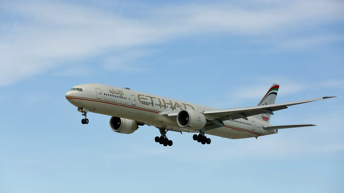 Finding Fares: A large jetliner flying through a blue sky.