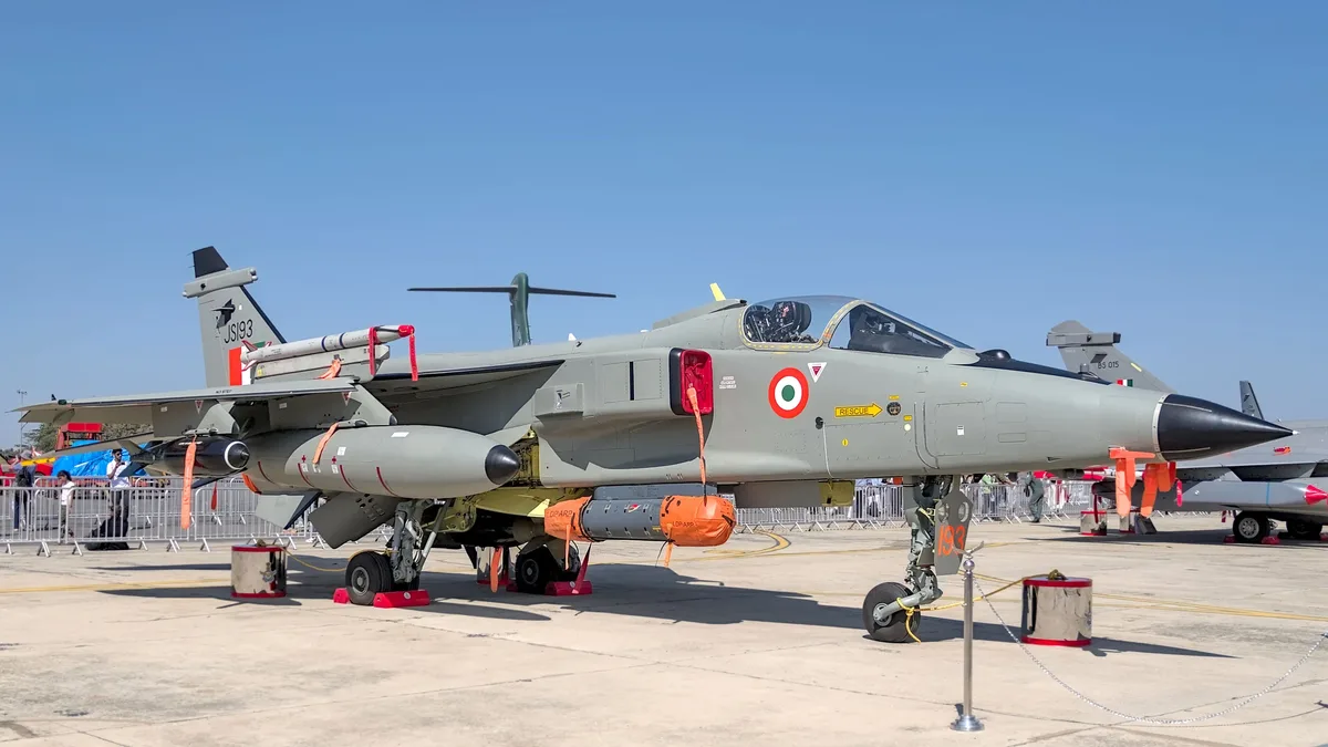 Roles Y Operaciones: Indian Air Force Jaguar on display at the Bengaluru airshow with clear blue skies.