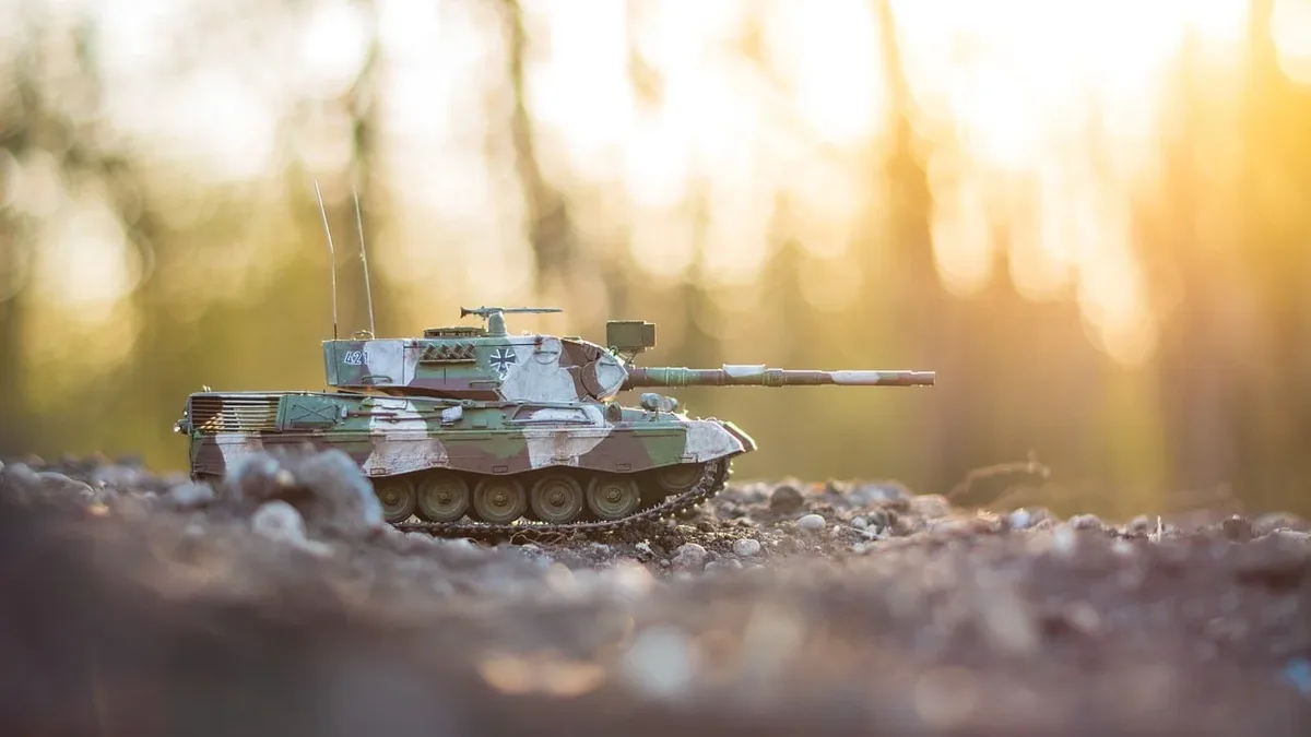 Conflict Security: A toy tank on a rocky surface, with the sun shining brightly in the background.