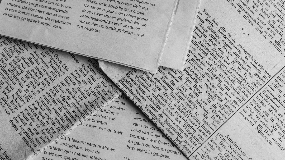 Temas: A stack of folded newspaper pages with text in a foreign language.